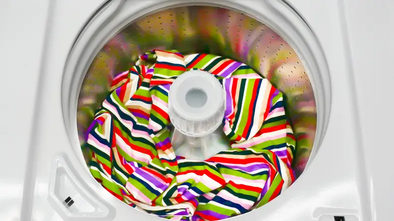 A shot of the interior tub of the Speed Queen TR5000WN AWN63RSN115TW01 top-loading washer, with a brightly-colored blanket at the bottom.