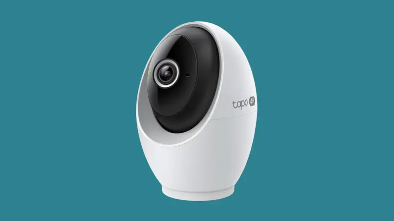 A white security camera on a teal background