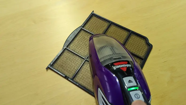 Cleaning a pre filter with a vacuum to protect the HEPA filter and keep air flowing.
