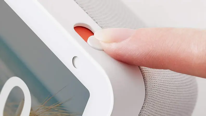 Finger touching the camera and microphone shutter switch on top of the Echo Show