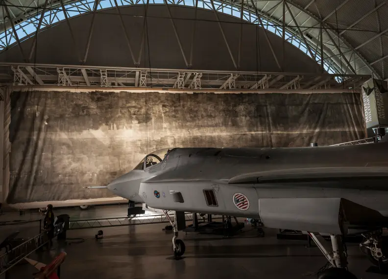 The Great Picture hangs behind a fighter jet in the Smithsonian