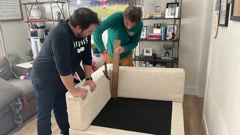 Two men building the sofa.