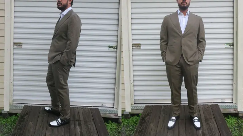 Man standing in front of storage shed wearing green cotton suit from Suitsupply.