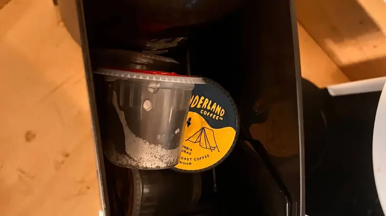 A few Bruvi coffee pods being held within the waste bin.