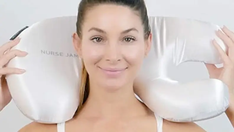 a woman holds the beauty bear pillow