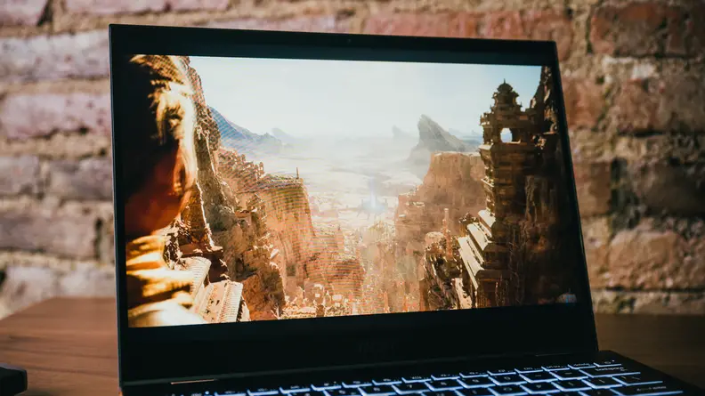 The laptop sits on a table, open and on.
