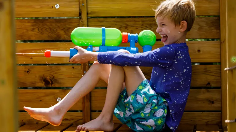 A boy shoots a Nerf Super Soaker