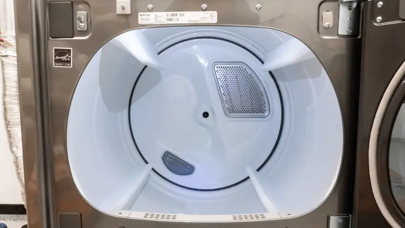 A close-up of the Maytag MED8230HC dryer's drum, lit by an internal LED