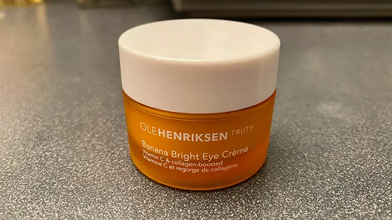 The OleHenriksen Banana Bright Eye Crème sitting on a bathroom vanity with its lid on.