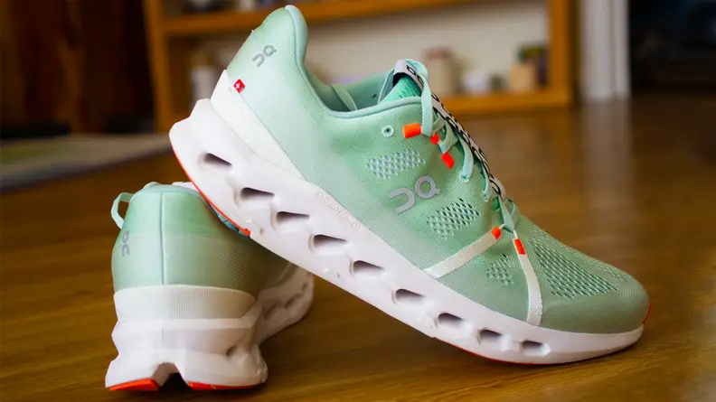 The On Cloudsurfer sneakers are positioned leaning against each other.