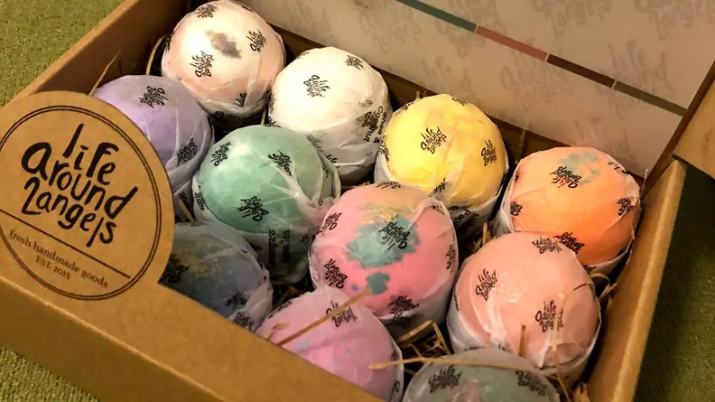 A box of spherical bath bombs, each a different color.