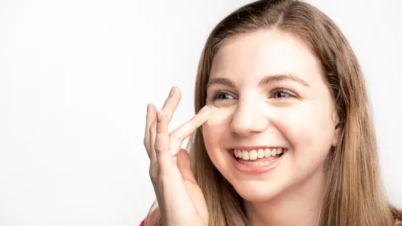 The author blending out the Tarte Shape Tape Concealer on her face.