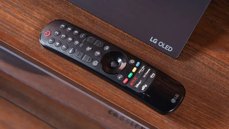 The remote of the LG C3 OLED TV on a TV stand.