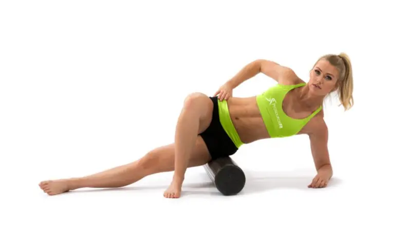 A woman foam rolling.