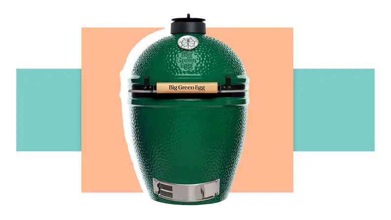 The Green Egg charcoal grill in front of a background.