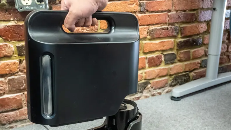 Empty the Shark IQ R101AE bin right into the trash.