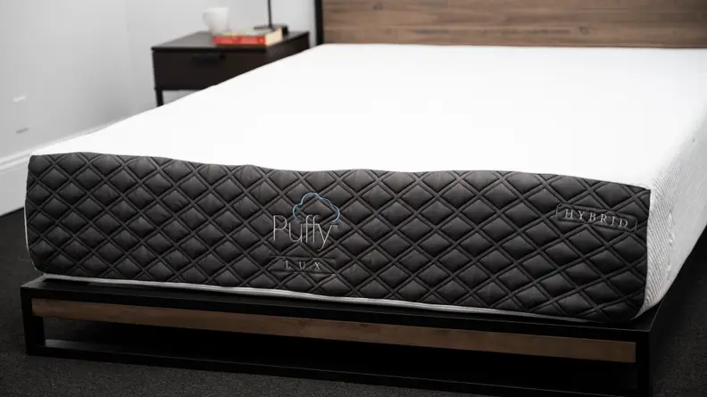 the puffy lux hybrid on a brown wood bed frame