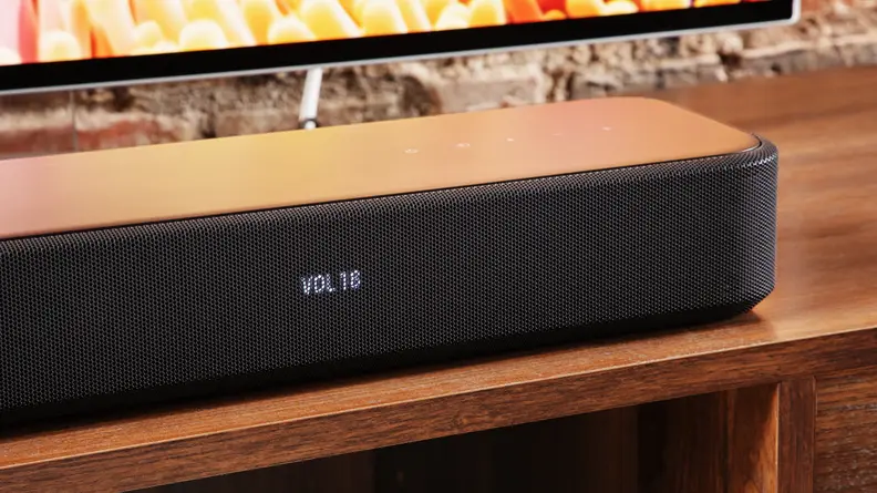 The Sony HT-S2000 soundbar on a wood table next to a TV.