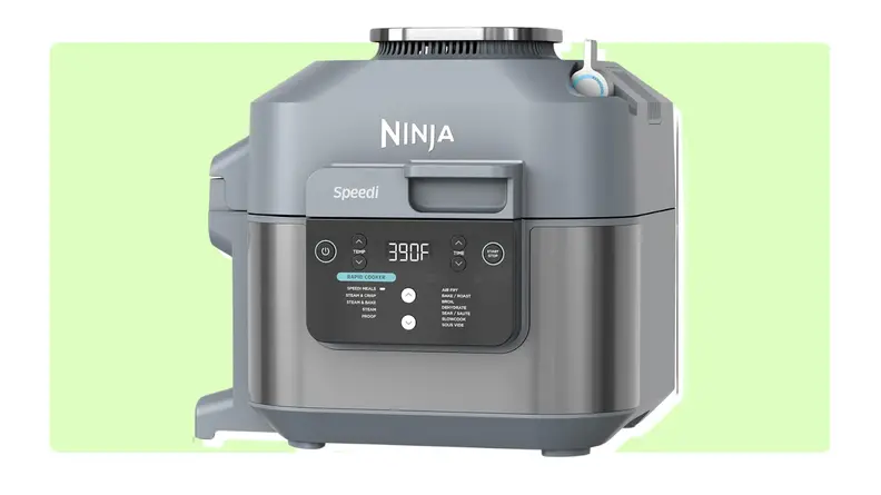 A gray Ninja Speedi air fryer in front of green background.