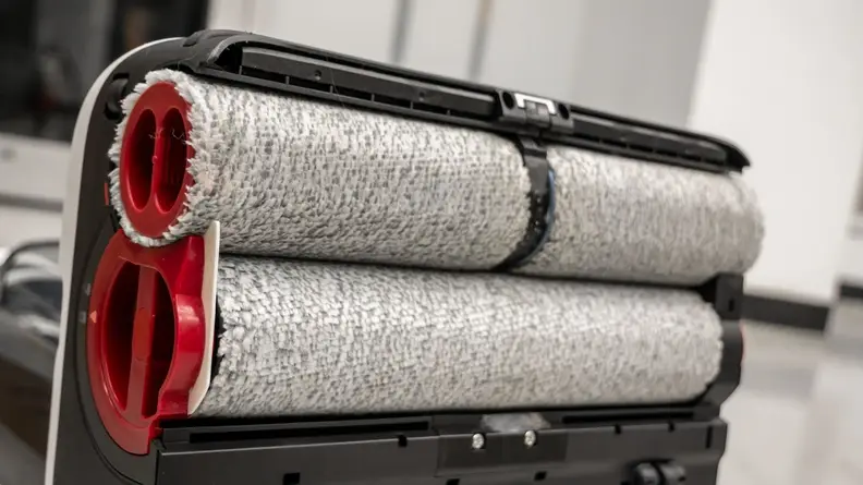 Three white rollers at the bottom of a vacuum cleaner