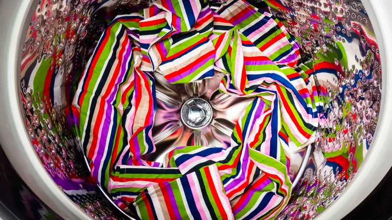 The stainless steel drum inside the LG WT7900HB washer, with a colorful towel at the bottom.