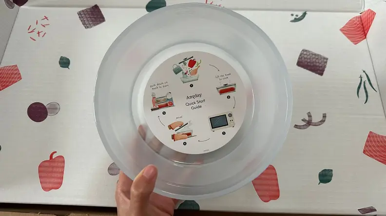 Clear microwavable bowl with lid and instructional information attached.