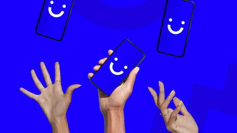 Hands holding phones with smiley faces on blue background