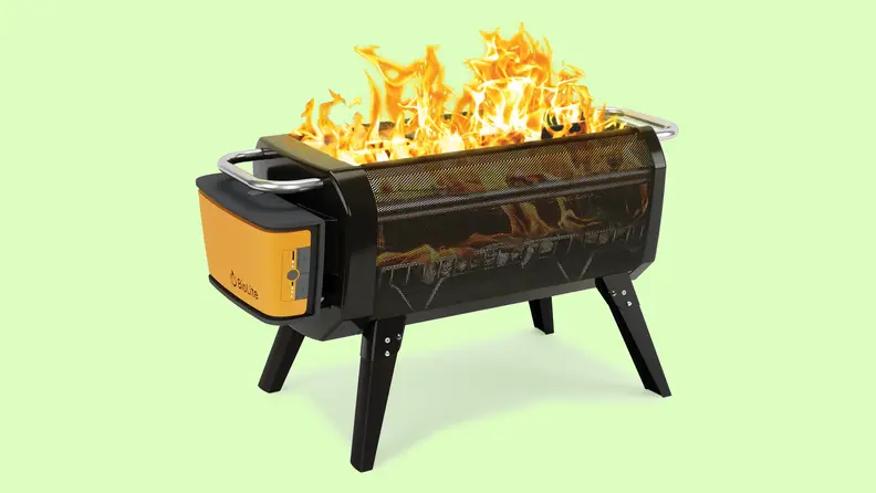 A portable fire pit sits on a green background.