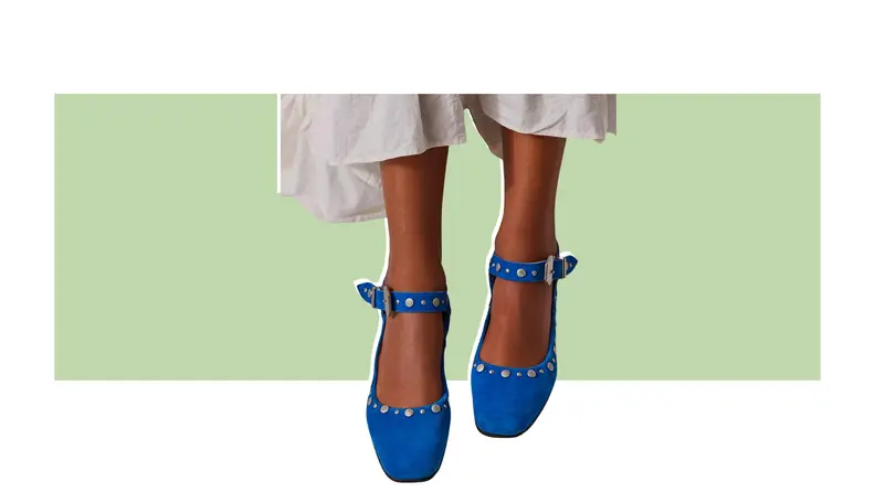 A pair of suede flats that have stud adornments.