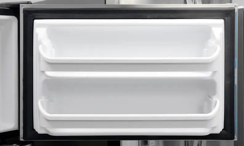 You'll notice some blue plastic around the door edges. That's leftover from the blue plastic coating meant to protect the Frigidaire FFTR1821QS's stainless finish in transit—and it's a nightmare to get off.