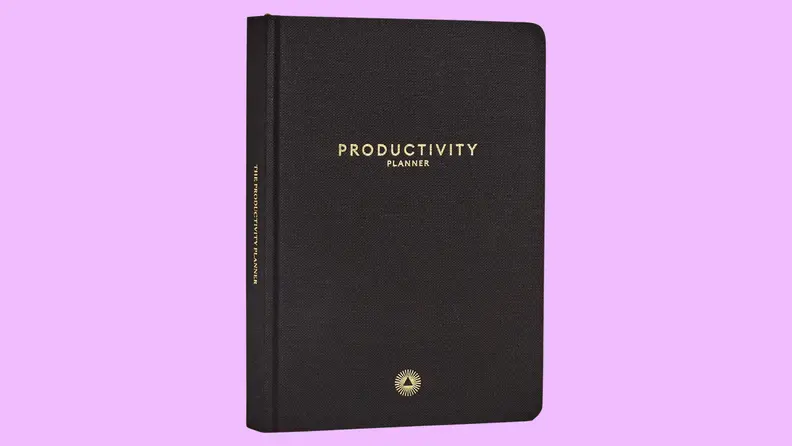 A black journal on a purple background.