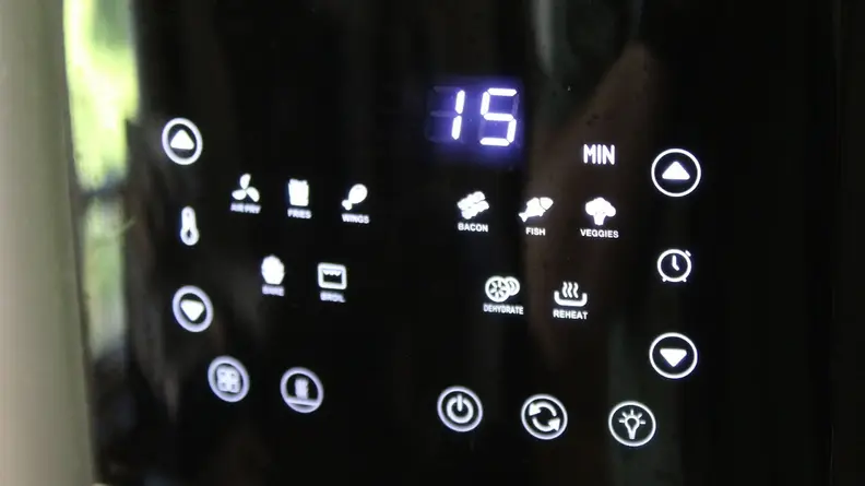 Control panel on the Kalorik 5-Quart Digital Air Fryer with assorted buttons lit up underneath the time display.