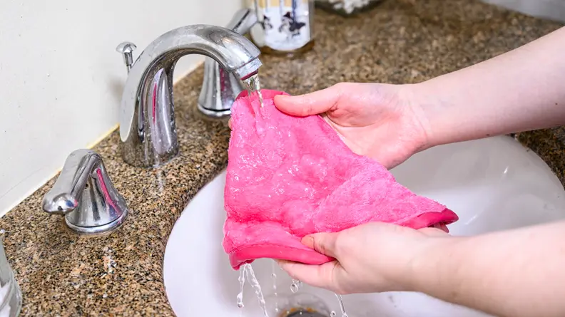 The author running the Makeup Eraser under the faucet.