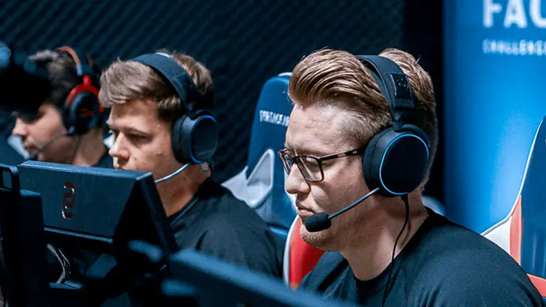 A competitive gamer sits at a computer while wearing the SteelSeries Arctis Pro headset, the best gaming headset you can buy right now..