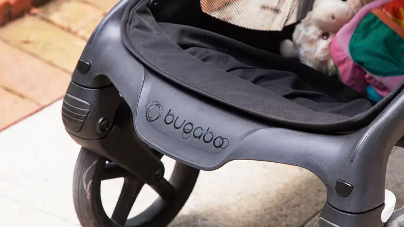 A close-up of the Bugaboo logo in black at the edge of the Bugaboo Fox 5 stroller in the color black.