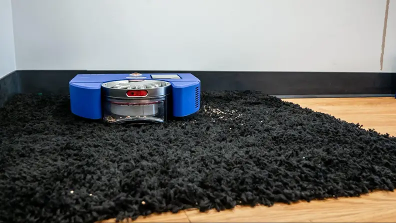 The Dyson 360 Vis Nav on a black throw rug.