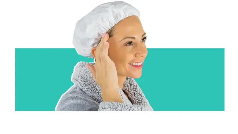 A person modeling the Vive No Rinse Shampoo Cap in front of a background.