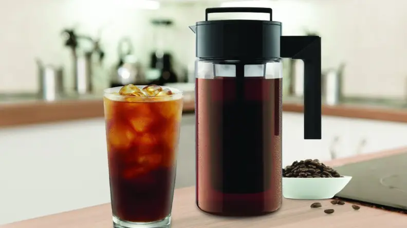 A glass of cold brew coffee next to the Takeya cold brew coffee maker