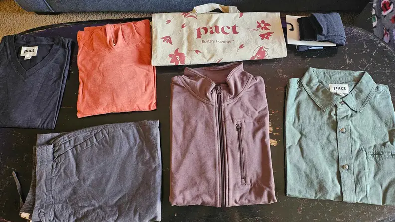 A set of clothes neatly folded on top of a coffee table.
