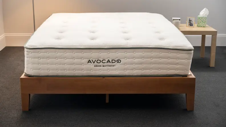 The foot of the Avocado mattress next to a small bed side table.
