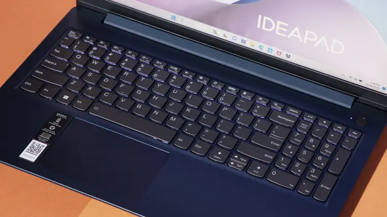 A top-down view of a laptop keyboard against a two-tone surface.