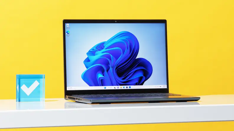The Dell Inspiron 14 Plus, open, on a desk with a yellow background.