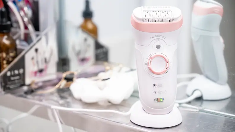 The Braun Silk-Epil 9 sitting on a sink in its holder.