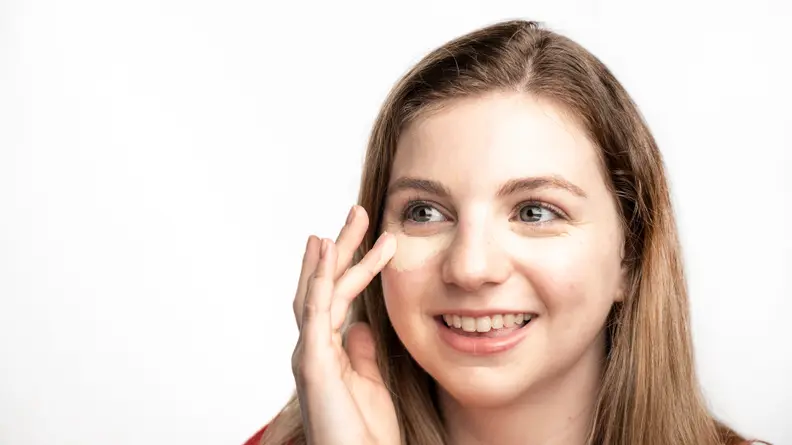 The author applying concealer under her eyes.