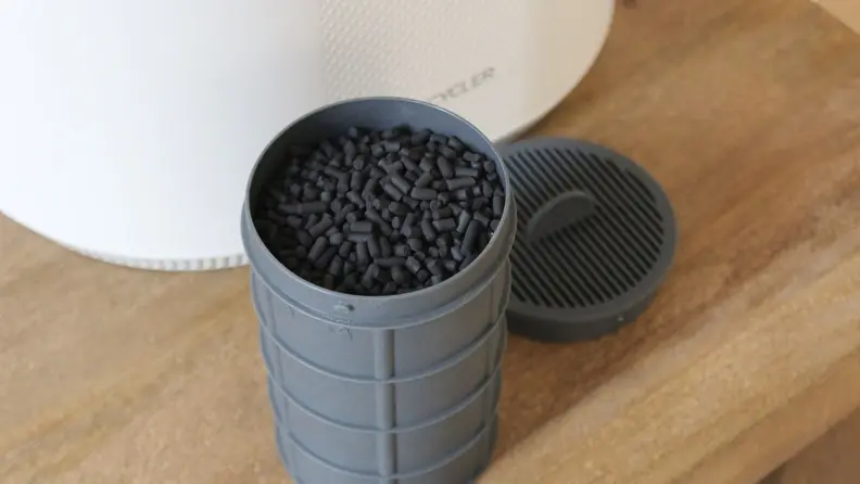A piece of the Vitamix Eco 5 FoodCycler machine with compost inside of the machine.
