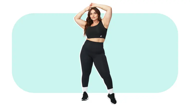 Model posing with arms above head while showcasing black Forme Power Bra, workout leggings, and sneakers.