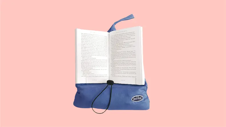 Front view of a book resting on the Book Seat in cinnabar red, a moldable pillow that holds books.