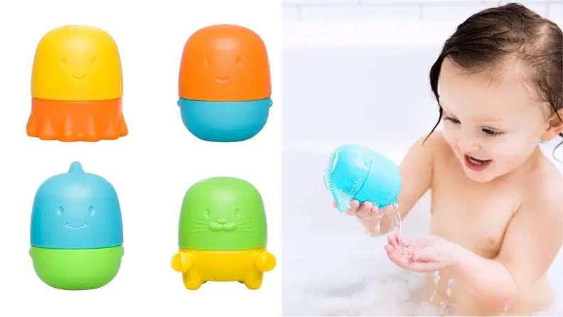 A little girl plays with multicolored bath toys in the tub.