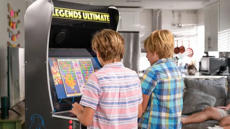 Two young boys playing the Legends Ultimate arcade cabinet.