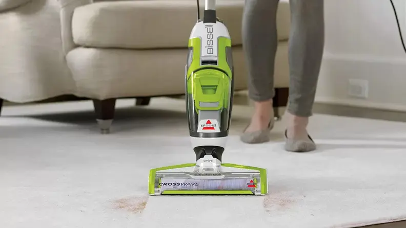A person vacuums a carpet.